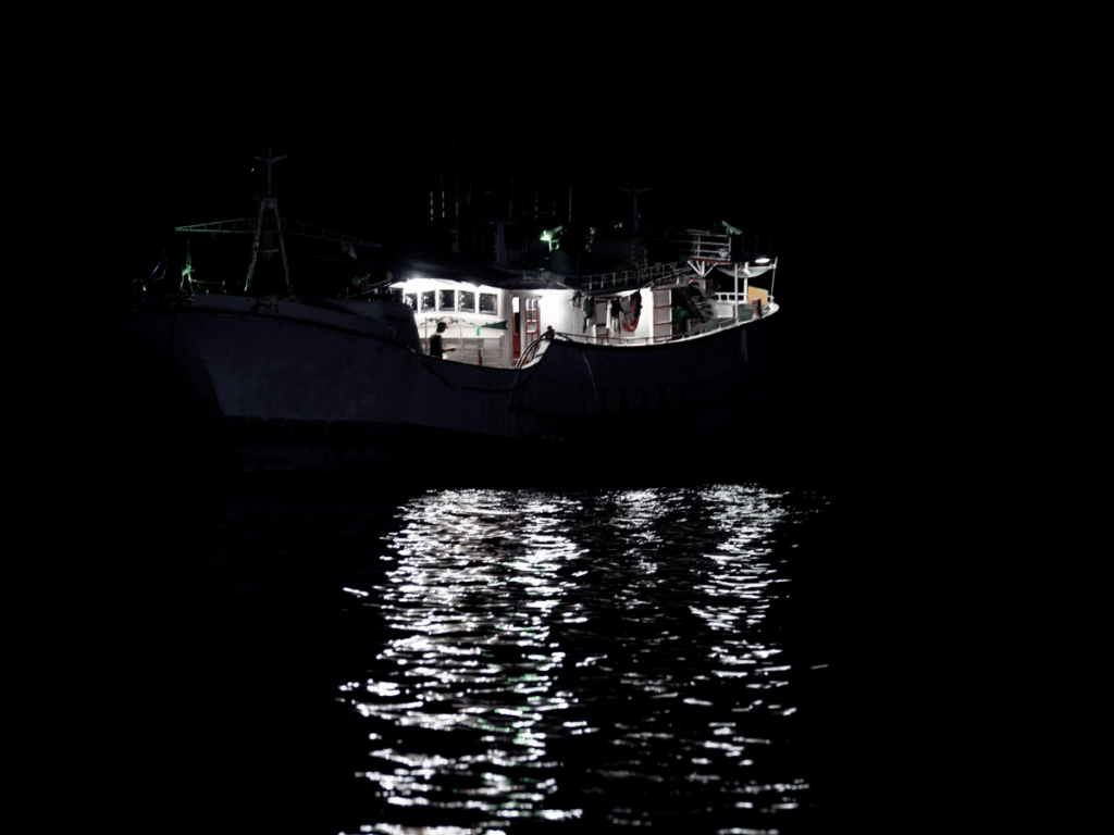 Peschereccio per calamari illuminato di notte in alto mare