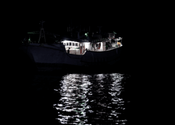 Peschereccio per calamari illuminato di notte in alto mare
