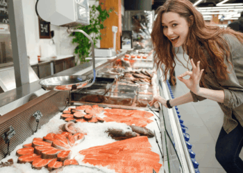 Cliente acquista una porzione di pesce fresco al banco