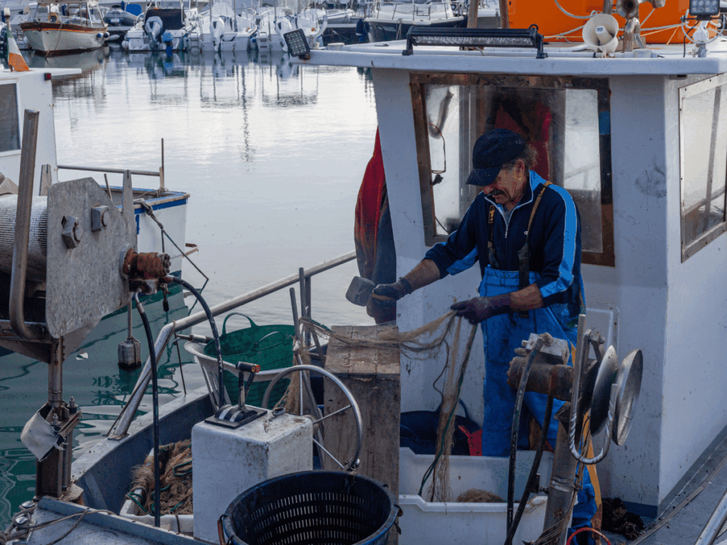 Pescherecci in porto e pescatori al lavoro, simbolo della crisi sociale della pesca europea