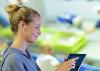 Operatrice utilizza un tablet in un mercato ittico digitalizzato