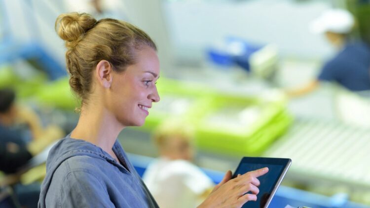 Operatrice utilizza un tablet in un mercato ittico digitalizzato