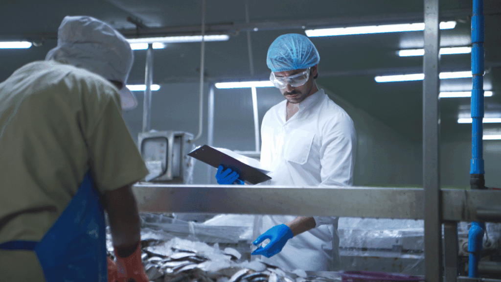 Operatore durante un controllo qualità sui prodotti ittici in uno stabilimento di lavorazione